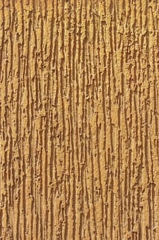 Fragment of light brown ornamental wall stucco covering 