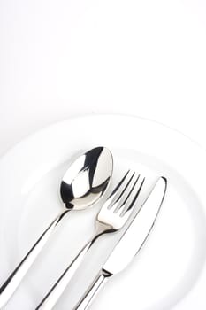 fork, knife, spoon and a white plate