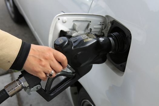 Close up of a person pumping gas.