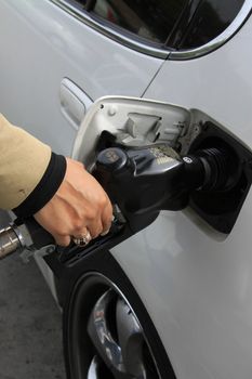 Close up of a person pumping gas.