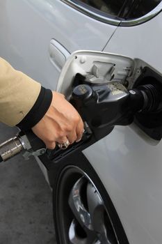 Close up of a person pumping gas.