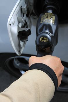 Close up of a person pumping gas.