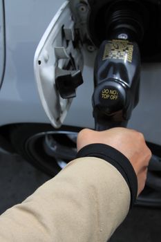 Close up of a person pumping gas.