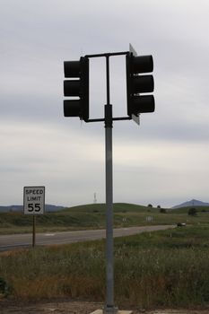 Traffic lights and a traffic sign over blue sky.