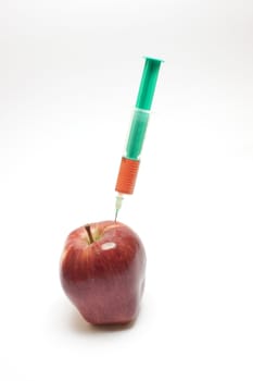 Red apple and syringe over white background