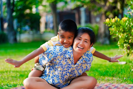 Mother and son play in a park