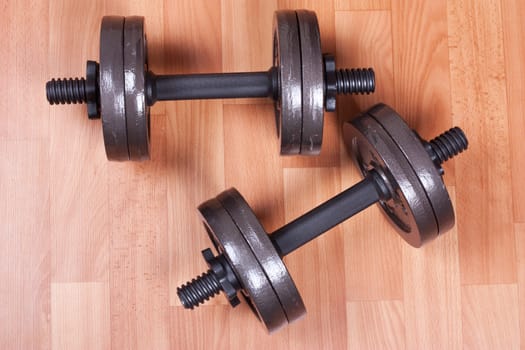 Two heavy dumbbells on a floor