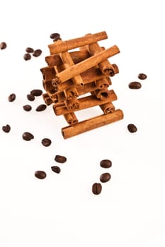 cinnamon sticks and coffee beans on white