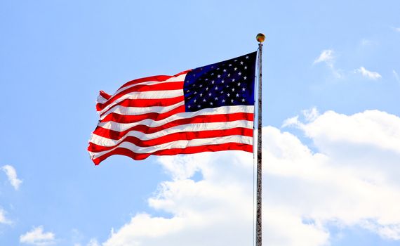American flag waving against blue sky  