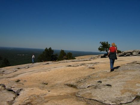 A photograph of a man and woman on top of Stone Mountain. Stone Mountain which is located near the city of Atlanta
in the state of Georgia in the United States, features the largest bas relief sculpture in the world. This sculpture shows Jefferson Davis (president of the U.S. Confederacy circa 1861 - 1865) and Confederate Generals Robert E. Lee 
and Thomas Jonathan "Stonewall" Jackson.