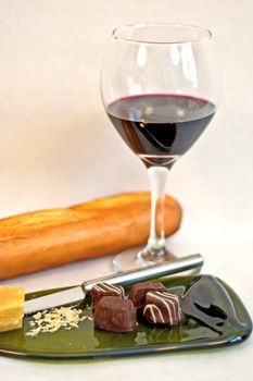 A wine & cheese with truffle plate with bread in the background.