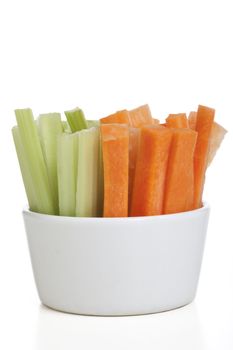 Bowl of carrot and celery sticks isolated on a white background.