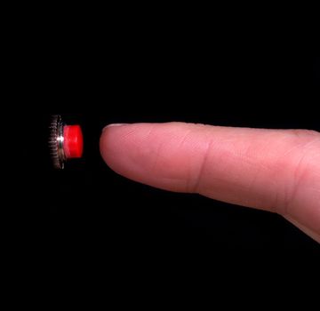 Finger about to push a red button