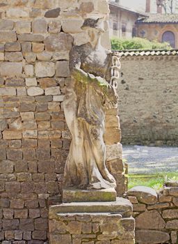 Stone statue of god Mercury near a stone wall