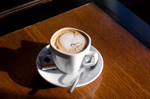 Cappuccino coffee cup closeup at the table