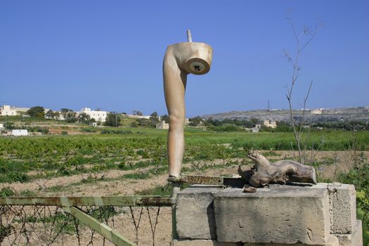 A part of an old mannequin is used as a gatepost in Malta