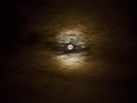 Full moon close-up and clouds against a black night sky