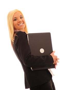Young confident business woman with blonde hair in a stylish dark suit, holding a laptop on a white background.