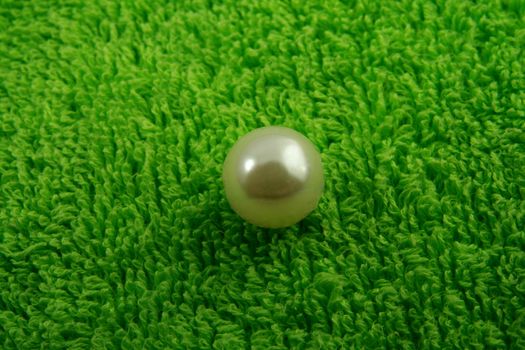 one pearl on green soft surface