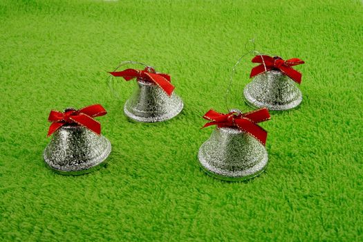 four bells with ribbons on soft green surface