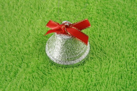 silver bell with red ribbon