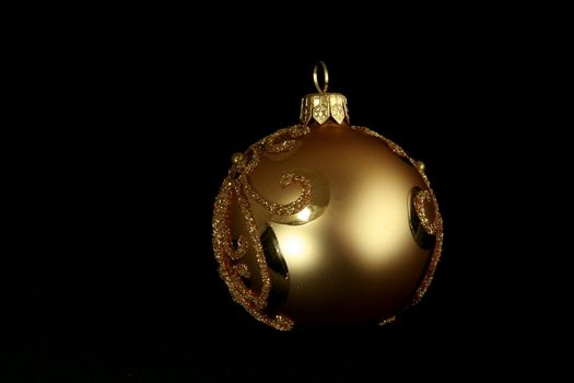 yellow decorative christmas ball isolated on black background