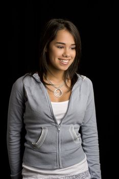 teen girl with great big smile against a black background