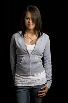 Teen girl standing against a black background