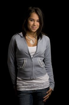 Young teen girl with shy smile against blackground