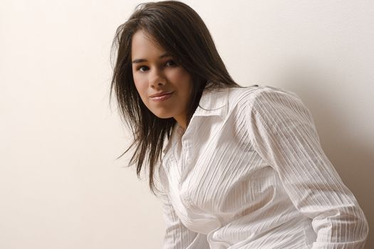 Young woman with white blouse against a white wall