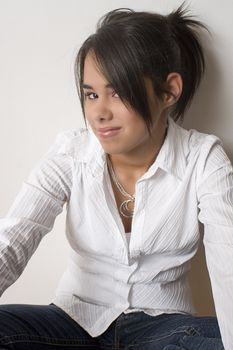 Young teen girl sitting cross legged hidding behind her hair
