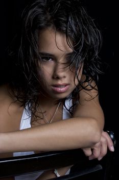 Teen girl with wet curly hair sitting on a chair