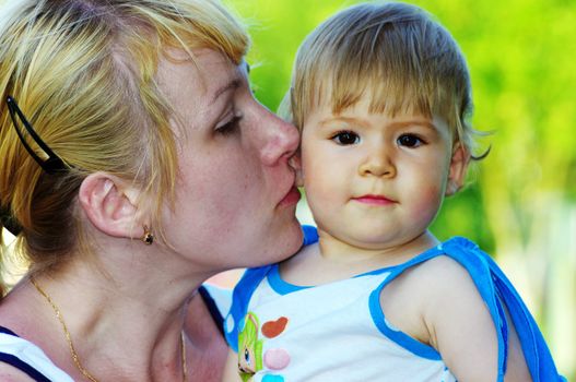 Mother Kissing Daughter. Daughter and mother outdoor.