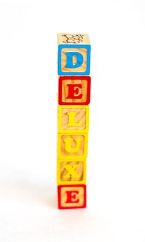 Vintage alphabet blocks spelling out DELUXE