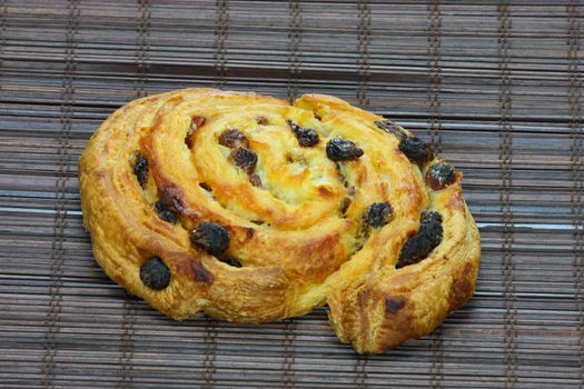 Freshly baked cinnamon roll on bakery paper 