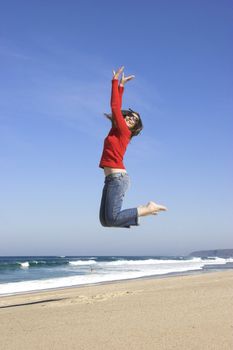 Young woman jumping on the beach