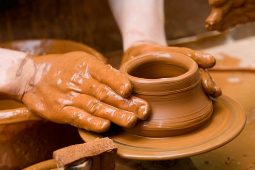 Potter shaping a ceramic plate on a pottery wheel