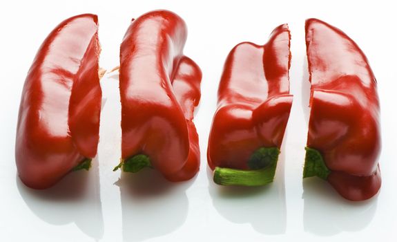 A red capsicum (bell pepper) sliced length ways into quarters. Isolated on white.
