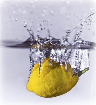A lemon dropping into water creating a splash