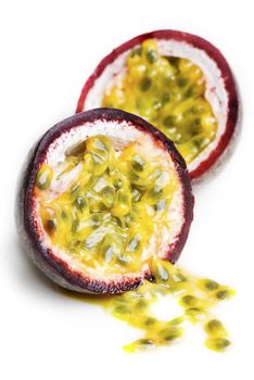 A passionfruit split in half with the seeds falling out.