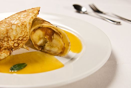 Caramel banana wrapped in a pancake with a sauce
