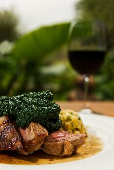 Lamb rump topped with steamed cabbage served with a nice glass of red wine.
