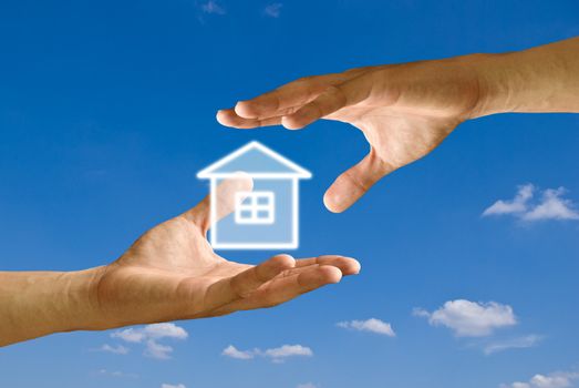 Hand take the house icon from other hand with blue sky