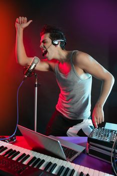 Dj with colorful light and music mixing digital equipment