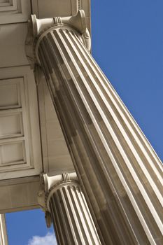 Greek ionic columns in London, set against a beautiful blue sky. 