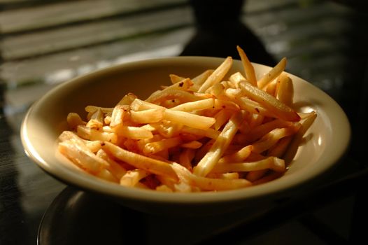 A bowl of french fries on top of table