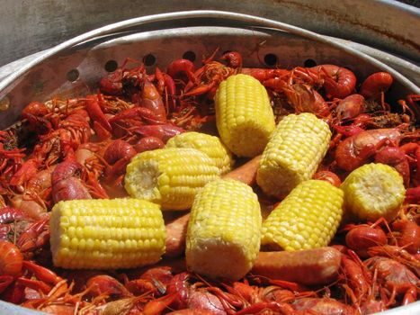 A crawfish boil in south Louisiana including crawfish, corn and sausage being cooked on an outdoor cooker.