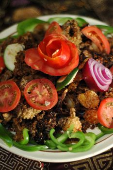 Calamari Seafood dinner garnished with tomatoes, onions, peppers and lemons