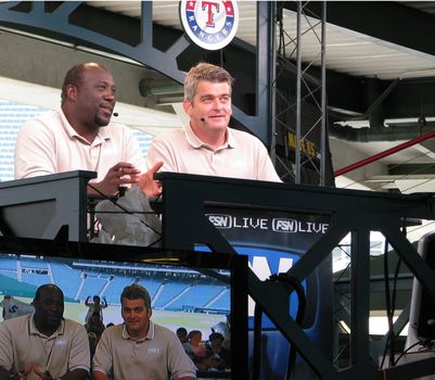 Two FSN Live commentators discuss the results of the Seattle Mariners and Texas Rangers ballgame on May 13, 2008 in Arlington, Texas. The photo captures them live and simultaneously being broadcast on television.