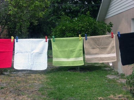 A colorful variety of face cloths are hanging on a clothes line.